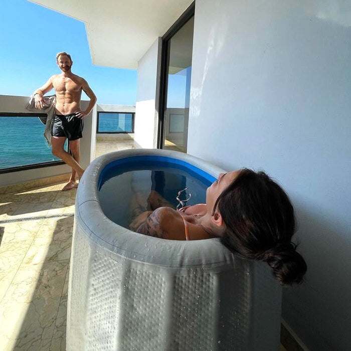 Inflatable plunge pool next to outdoor traditional sauna on balcony with ocean view