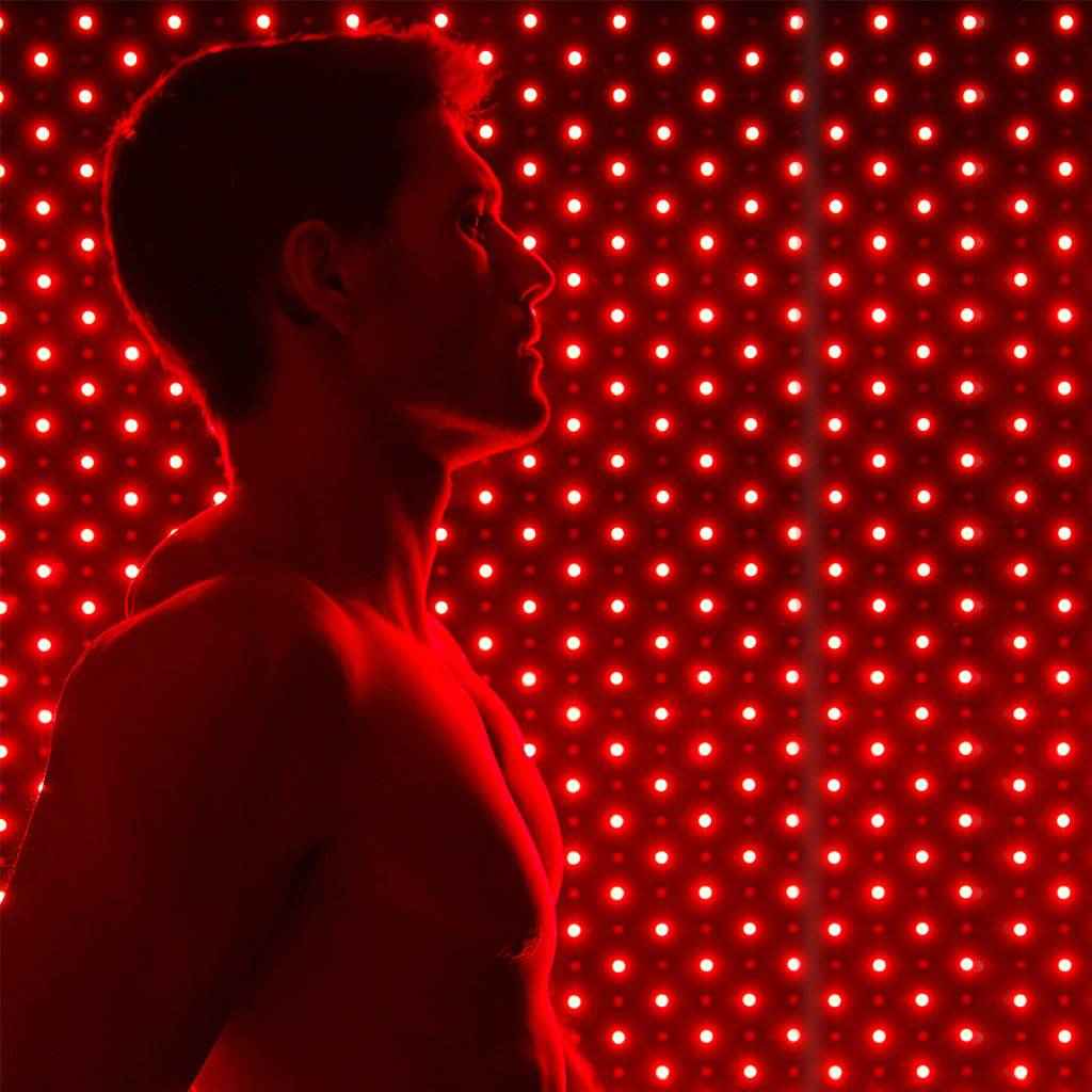 Man using Nushape Red Light Therapy Mat with 660nm and 850nm LEDs for full-body recovery and healing