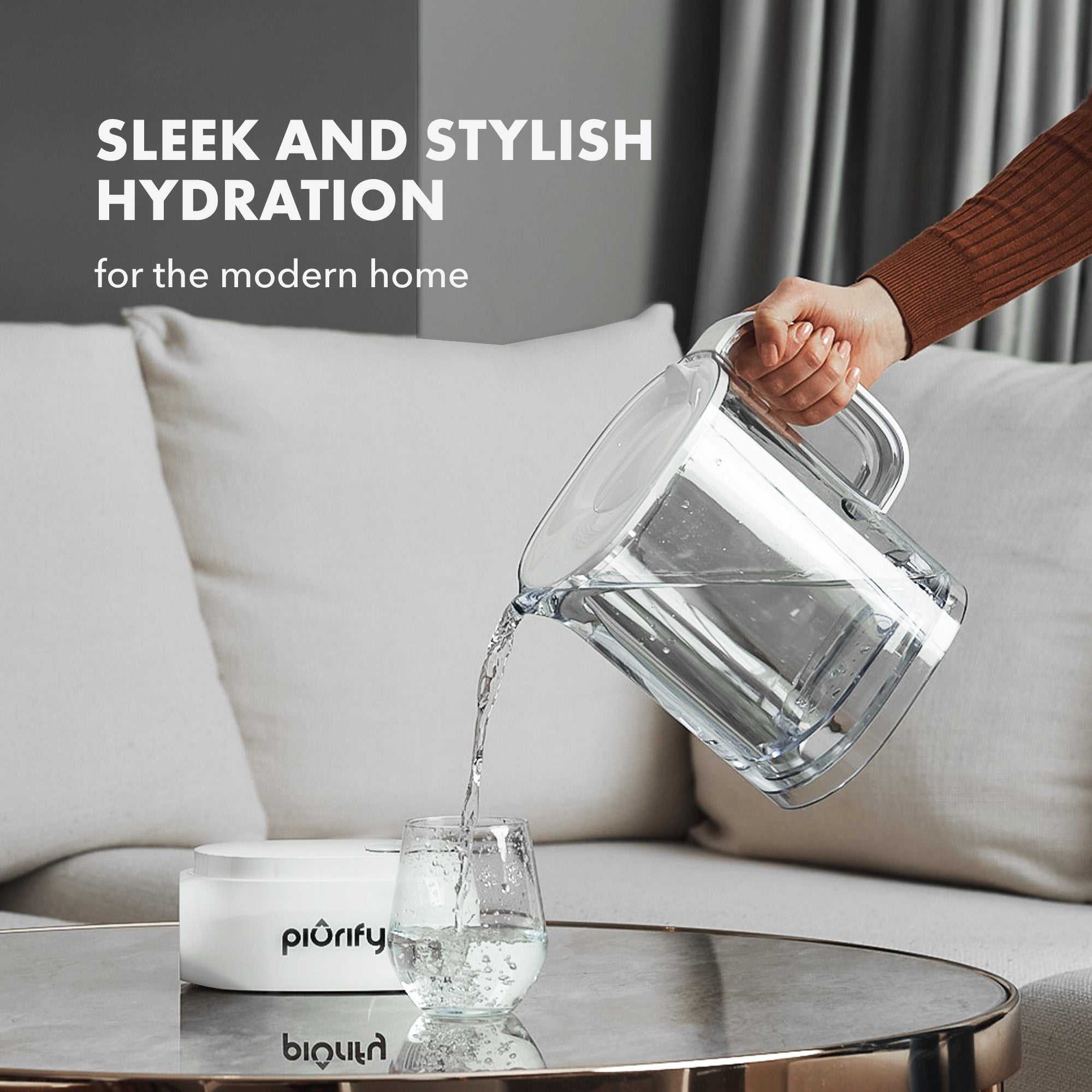 ALCHEMY® Electric Filter Pitcher pouring clean water into glass on table in modern home setting
