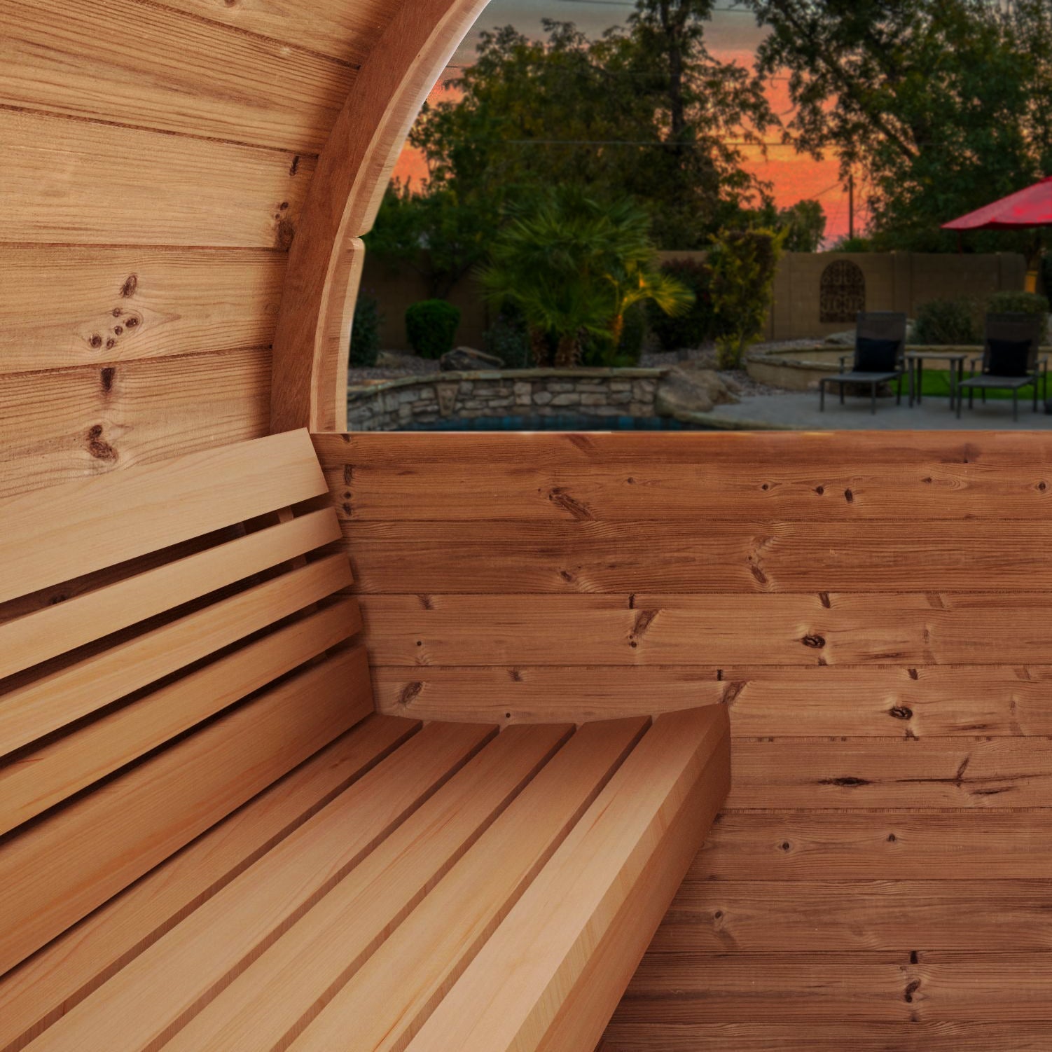 Interior view of SaunaLife Model E7W Sauna Barrel with ergonomic Thermo-Spruce benches and panoramic half-moon window at sunset