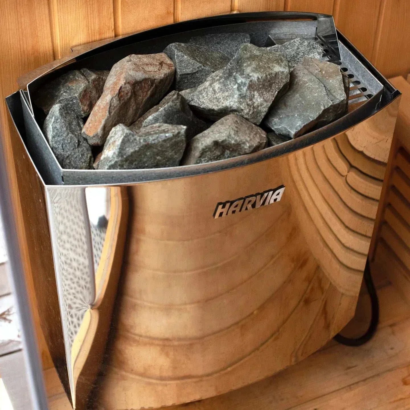 Harvia heater with sauna stones in a traditional wood-paneled sauna room