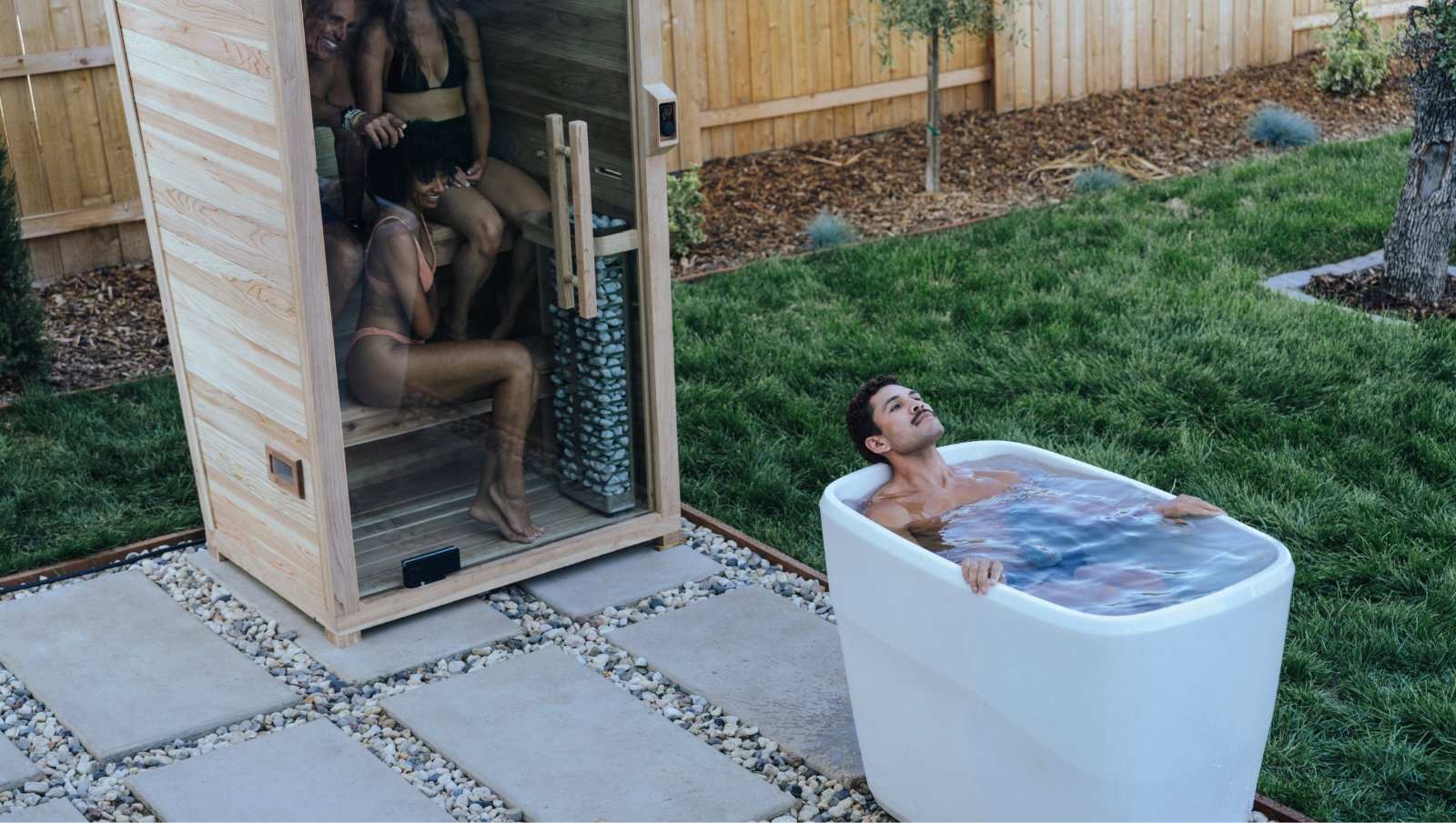 Plunge Pod + Sauna Mini Bundle with man in cold plunge tub and three people in wooden infrared sauna outdoors