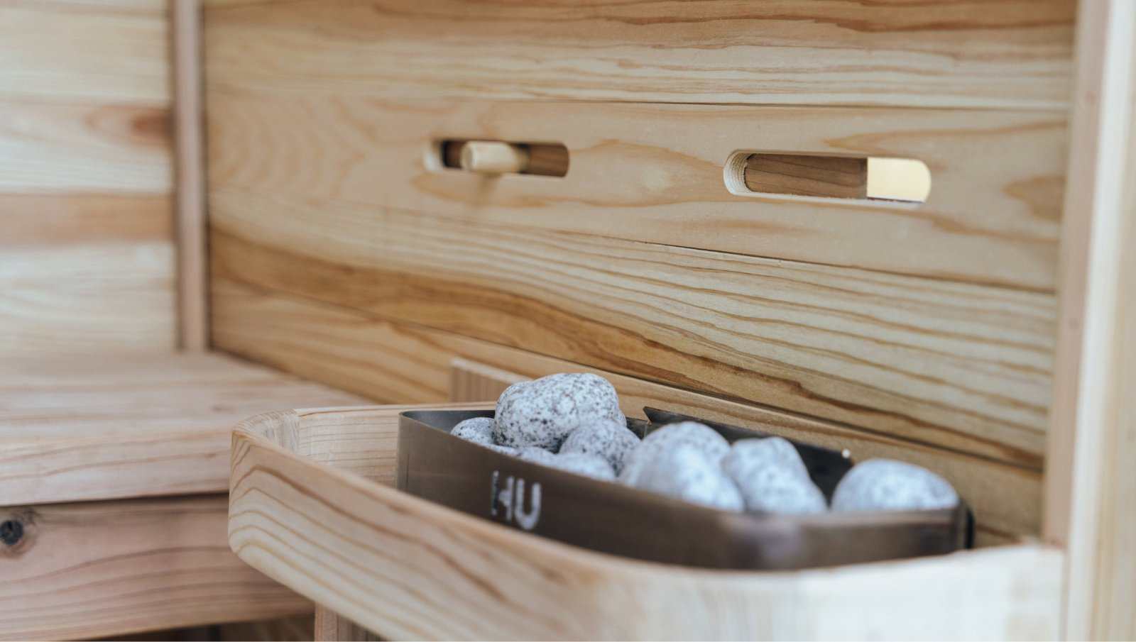 Close-up of sauna heater with stones inside wooden Plunge Pod + Sauna Mini Bundle home recovery unit