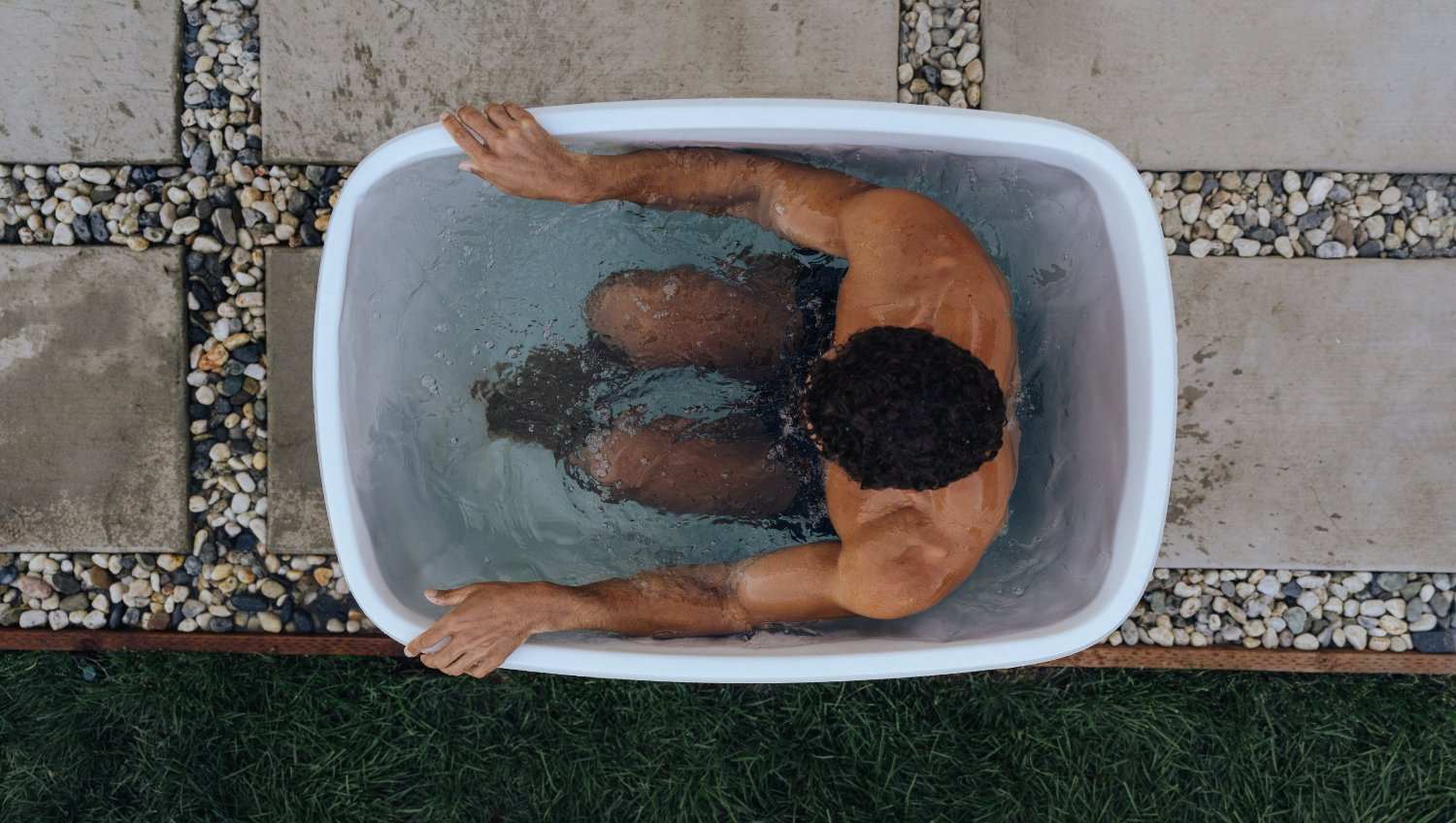 Top view of a person using a portable cold plunge tub for home recovery and wellness