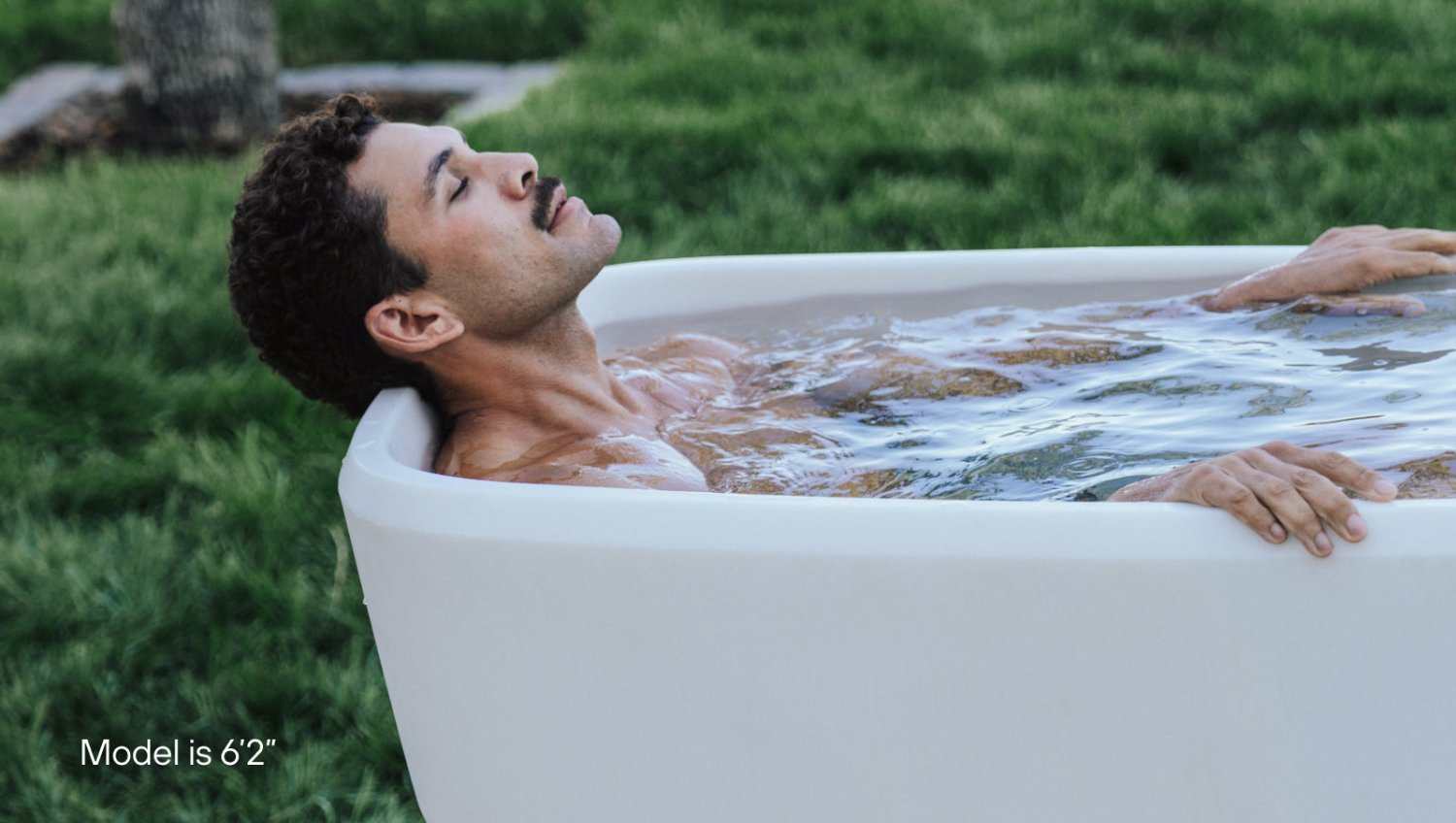 Man relaxing in Plunge Pod cold plunge tub outdoors for recovery and wellness