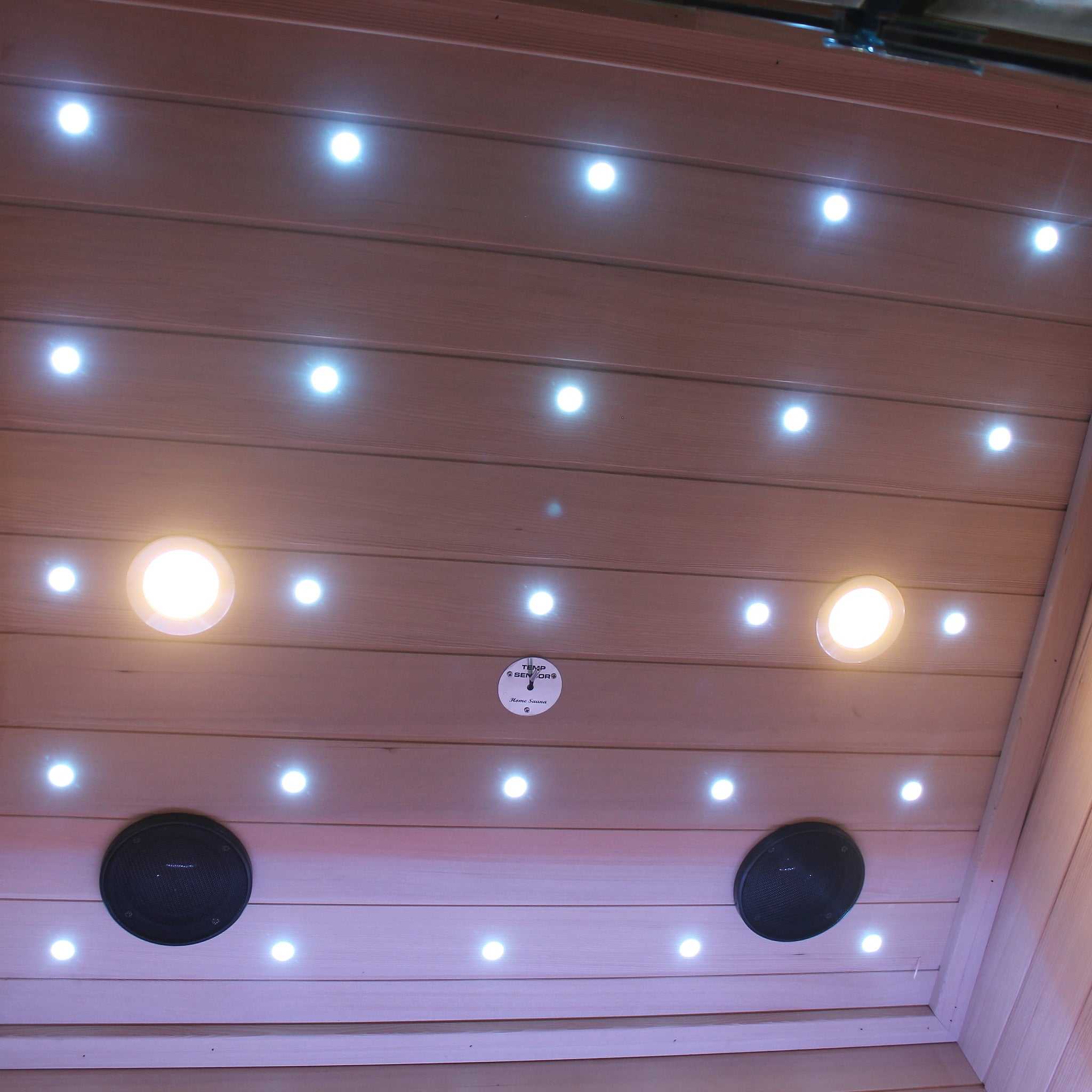 Interior ceiling of a traditional sauna with LED lighting and Bluetooth speakers installed