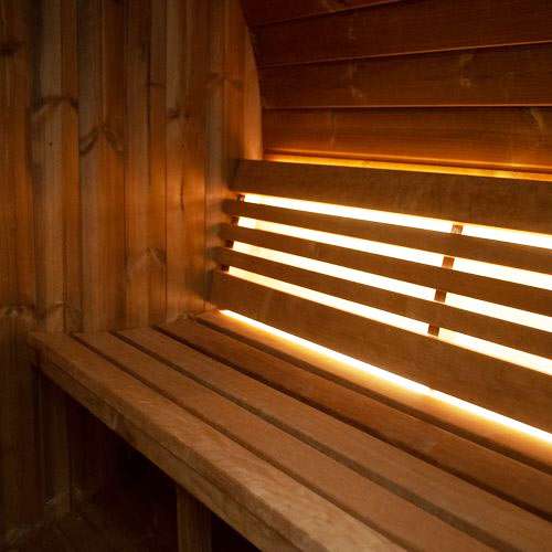 Interior view of SaunaLife Model E8W barrel sauna with illuminated Thermo-Aspen benches and wooden walls