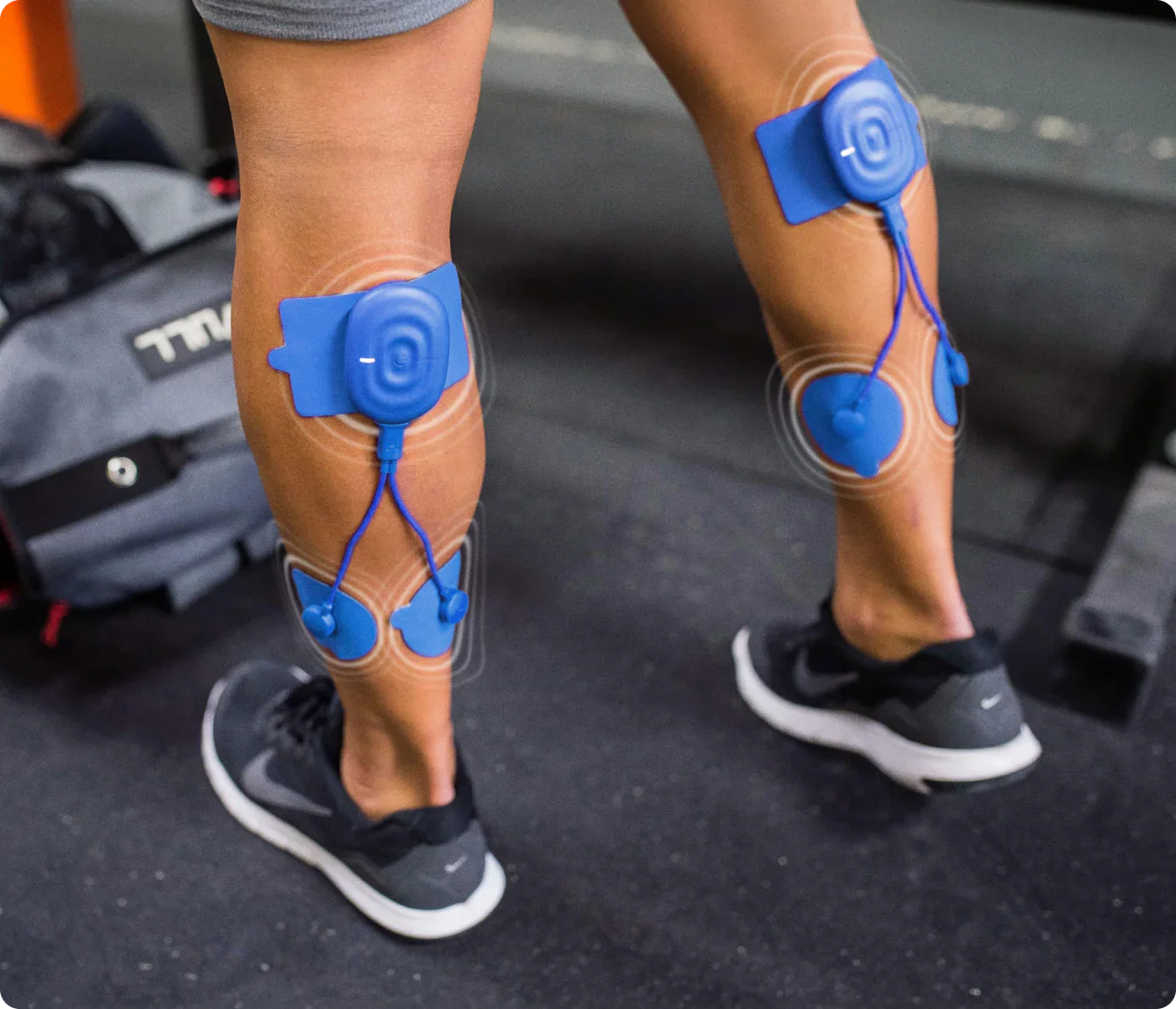 Person wearing Power Dot DUO muscle stimulators on calves during workout