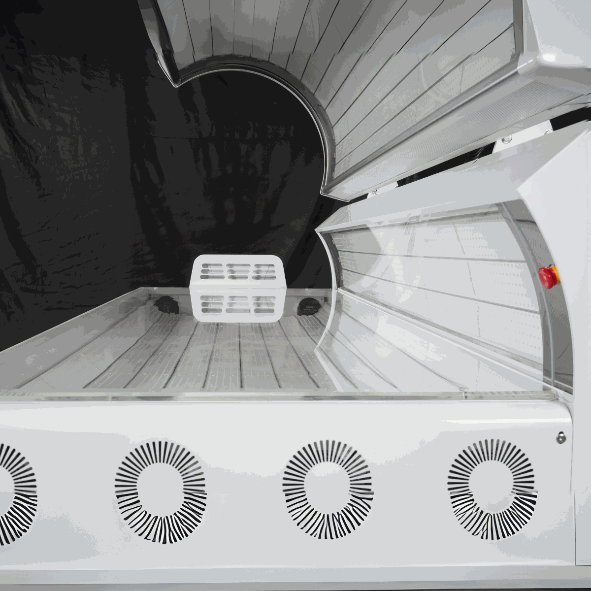 Open red light therapy bed with interior LED panels and cooling fans ready for use