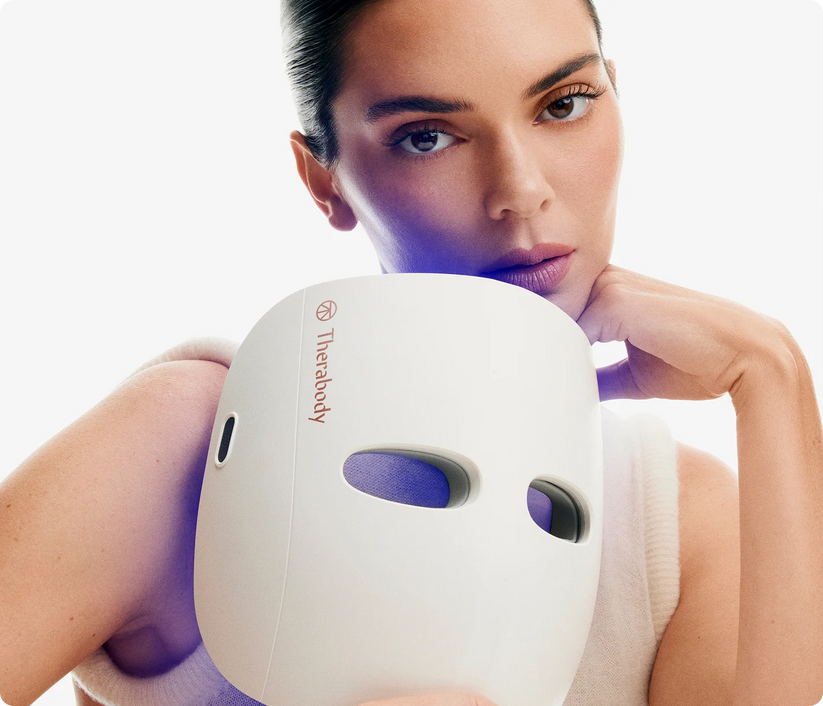 TheraFace Mask cordless LED light therapy device held by woman for anti-aging skincare