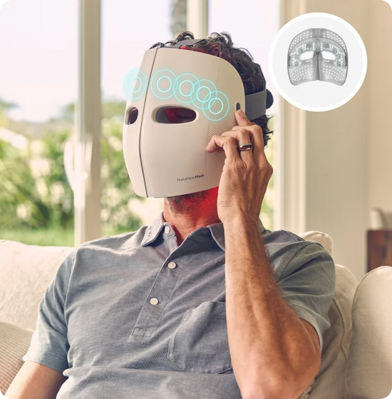 Man wearing TheraFace Mask full-face LED light therapy device for skincare treatment at home