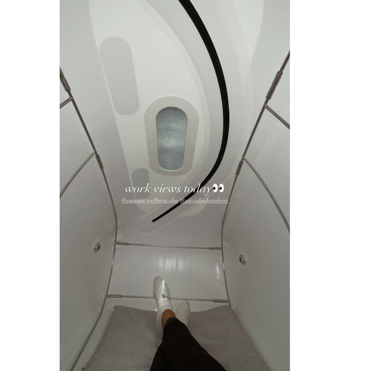Interior view of Airvida Pro90 portable seated hyperbaric chamber with reclining user's legs visible