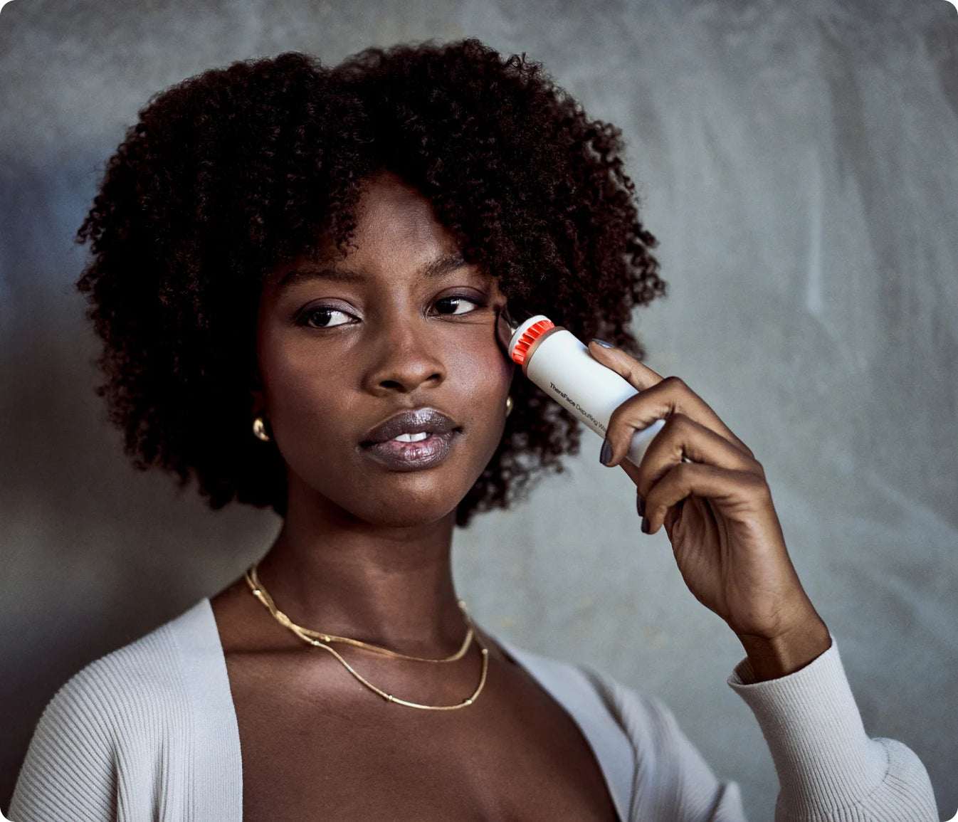 Woman using TheraFace Depuffing Wand for under eye massage to reduce puffiness and dark circles