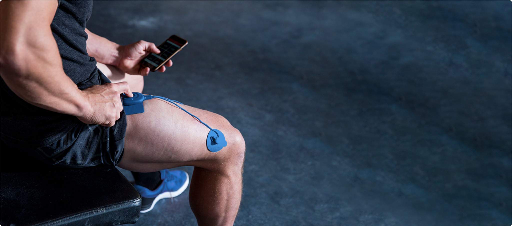 PowerDot Uno muscle stimulator on thigh controlled by smartphone app