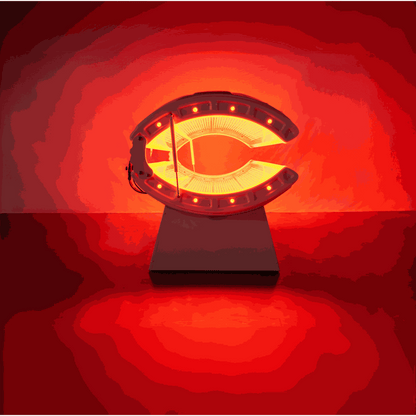 Red light recovery system bed emitting red light on a white stand against red background