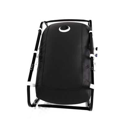 Black vertical sitting hyperbaric chamber with external frame, angled view showing zipper door and viewport windows