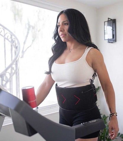 Woman wearing MitoQUAD Wavelength Belt for hands-free red light therapy during treadmill workout